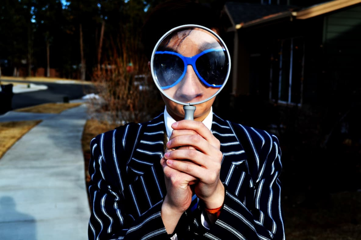 Man looking at the camera through a magnifying glass